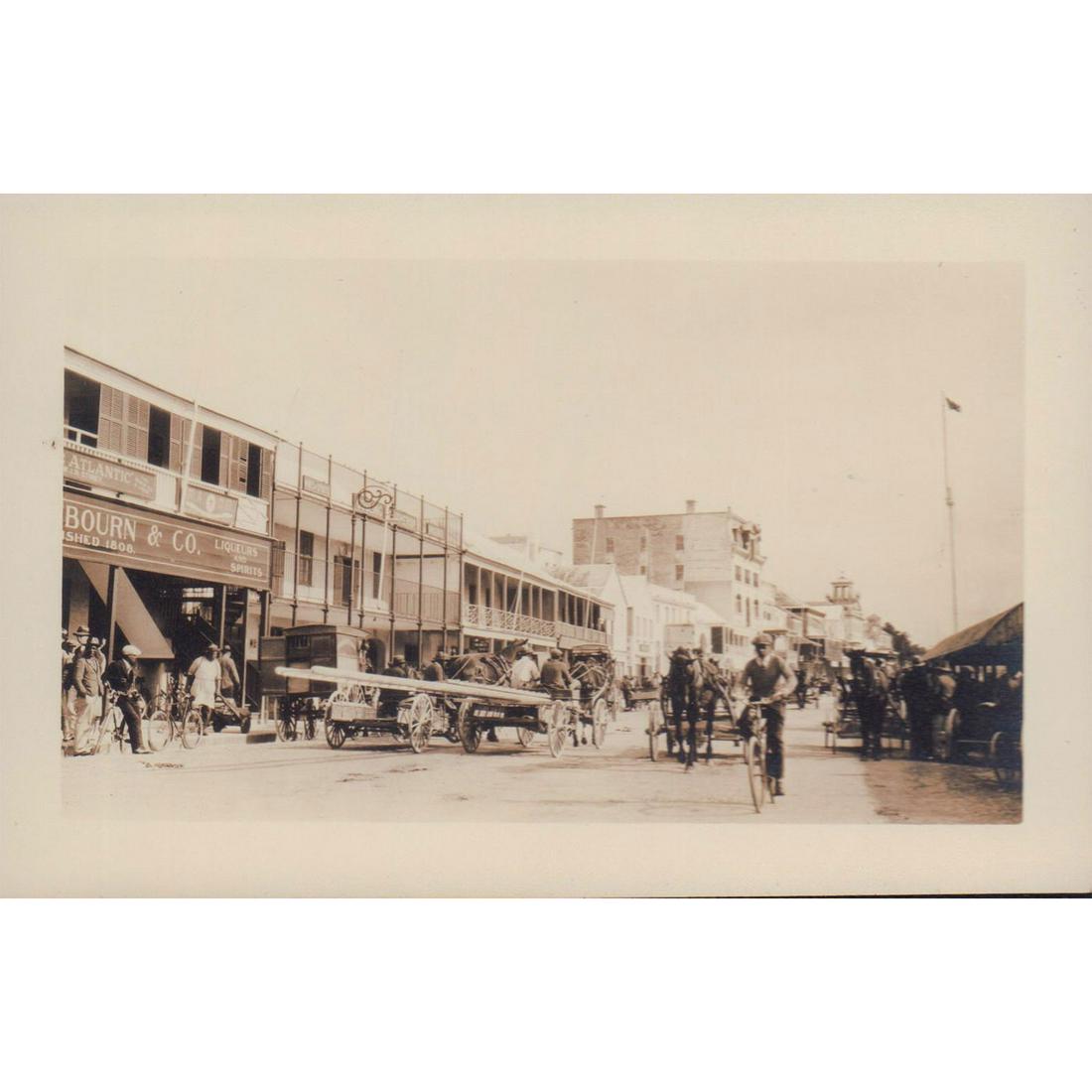 Vintage Black and White Cityscape Photo of Bermuda: A lively moment of shopkeepers and town-folks on Front Street, Hamilton. Gosling Brothers LTD. rum shop can be seen. Issued: c. 1930s Dimensions: 5.25"W x 3.5"H Manufacturer: Bermuda