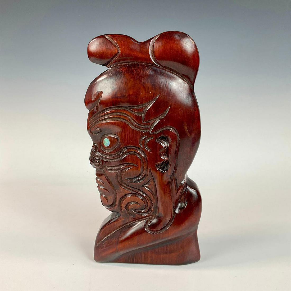 Maori Warrior Hand Carved Wooden Sculpture: A beautiful carving of the side profile of a man with mother pearl for an eye. Dimensions: 5.5"L x 2"W x 11"H