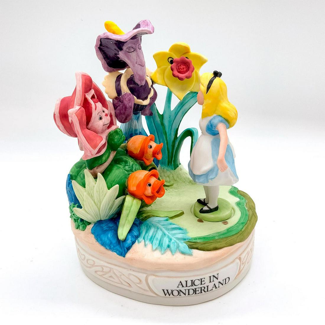 Walt Disney Ceramic Music Box, Alice in Wonderland: Part of the Disney Collection Musical Memories Series. Depicts character Alice with the talking flowers. Walt Disney Productions backstamp. Dimensions: 5.25"L x 5"W x 7"H Edition Number: 3138/19750 Ma