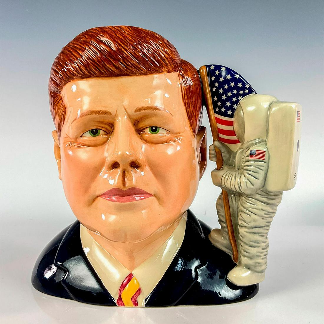 John F. Kennedy D7246 - Royal Doulton Character Jug: Brown, dark blue, white, grey, and red. Royal Doulton backstamp. Issued 2005 in a limited edition of 1,000. Royal Doulton and Pascoe backstamps. Artist: Ray Noble Issued: 2005 Dimensions: 6.5"H Editio