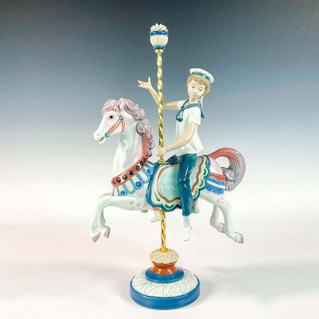 Boy On Carousel Horse 1001470 - Lladro Porcelain Figurine: Glossy finish; Lladro backstamp. Includes original box. Box measures: 15.75L x 12.5W x 7.5H. Artist: Jose Puche Issued: 1985 - 2000 Dimensions: 15"H x 9"W Manufacturer: Lladro Country of Origin: