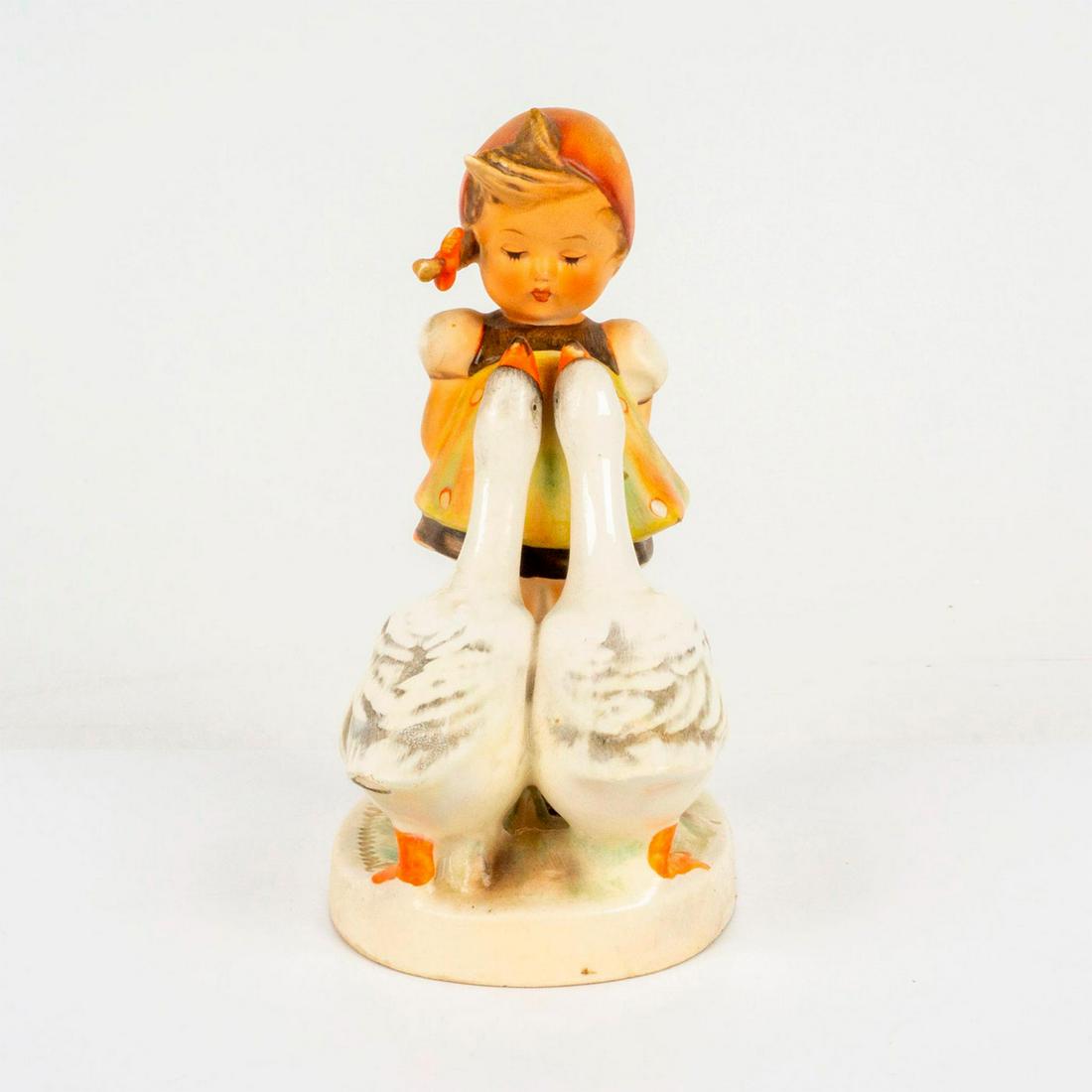 Goebel Hummel Figurine, Goose Girl: Porcelain hand painted in matte finish. Goebel backstamp. Impressed M. I. Hummel to round base. Dimensions: 3.25"L x 2.25"W x 4.75"H Manufacturer: Goebel Hummel Country of Origin: Germany
