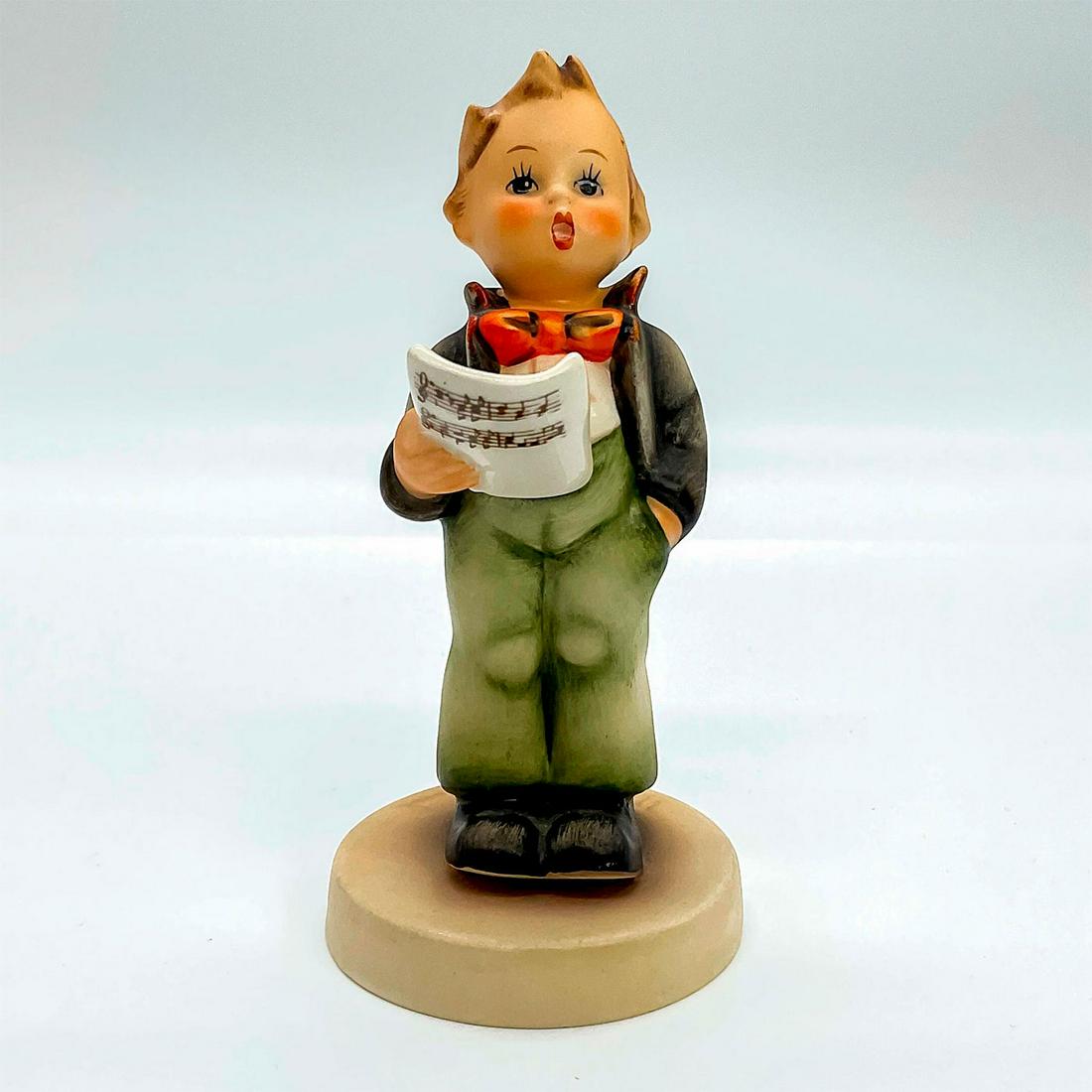 Goebel Hummel Figurine, Soloist: Porcelain hand painted in matte finish. Goebel backstamp. Impressed M. I. Hummel to round base. This item has no reserve. Artist: M. I. Hummel Issued: 20th c. Dimensions: 1.5"W x 4.75"H x 2.25"Dia. Ma