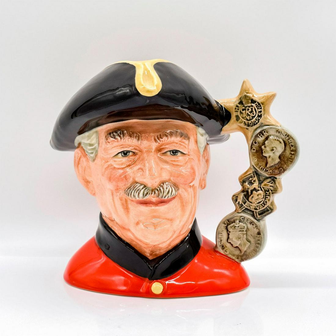 Chelsea Pensioner D6830 (Hornes backstamp) - Large - Royal Doulton Character Jug: Black tricorn trimmed with gold; scarlet tunic; black collar. Charles II founded the Royal Hospital for "worthy old soldiers broken in the wars." it was built by Christopher Wren and completed in 1692