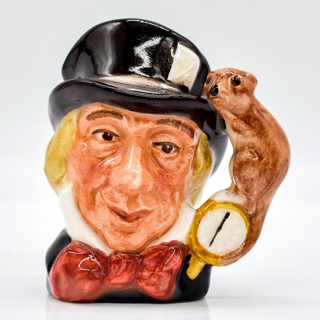 Mad Hatter D6606 - Mini - Royal Doulton Character Jug: Variation One, black hat; dark red bow tie. A character from Lewis Carroll's "Alice's Adventures in Wonderland," the Mad Hatter wears a watch that tells time in months, rather than in hours. Series: A