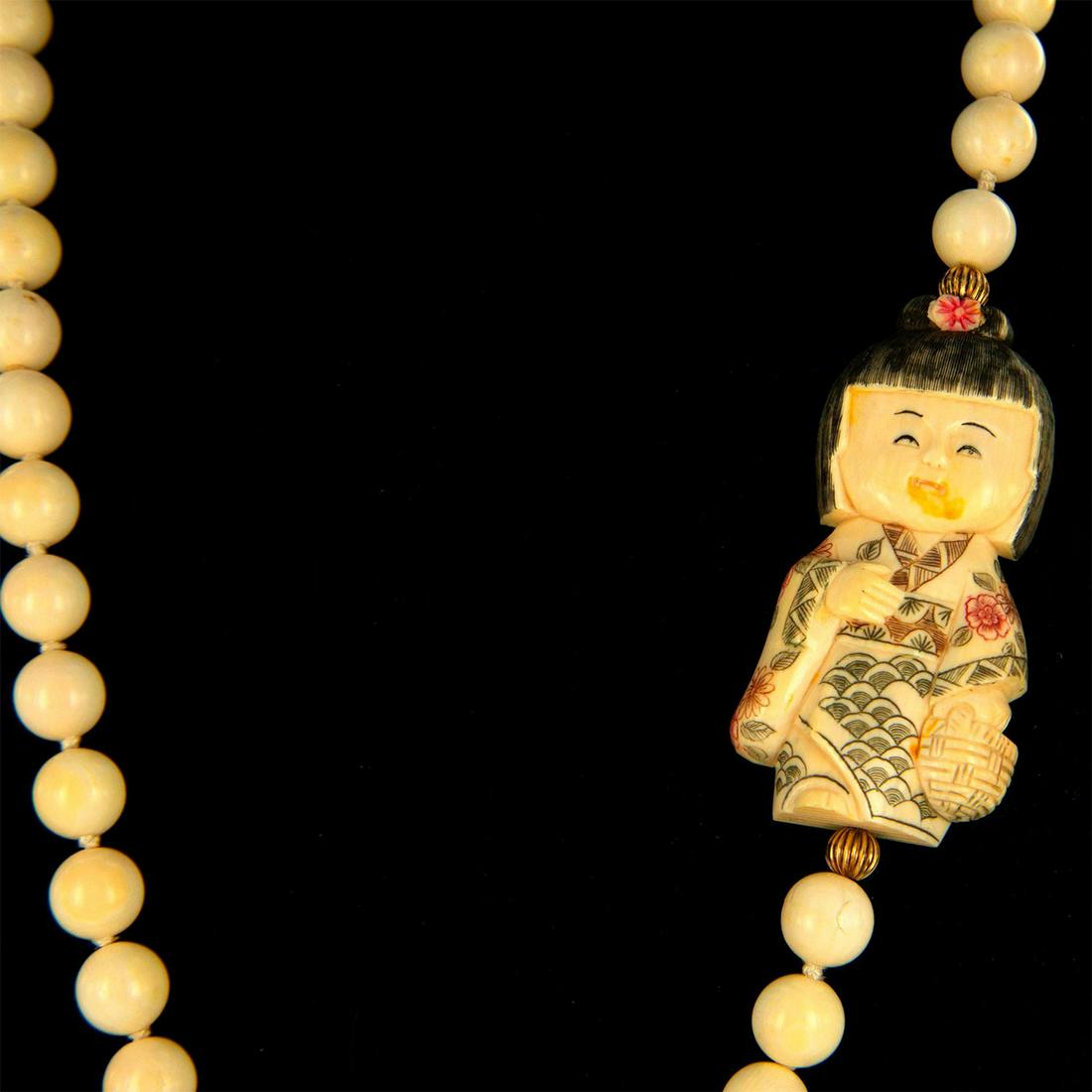 Vintage Japanese Carved Bone Netsuke Necklace: Beautiful strand beaded necklace with a Geisha in traditional kimono pendant . Measures approx. 18"L, girl is 3"x 1.5". Total weight 130 grams.