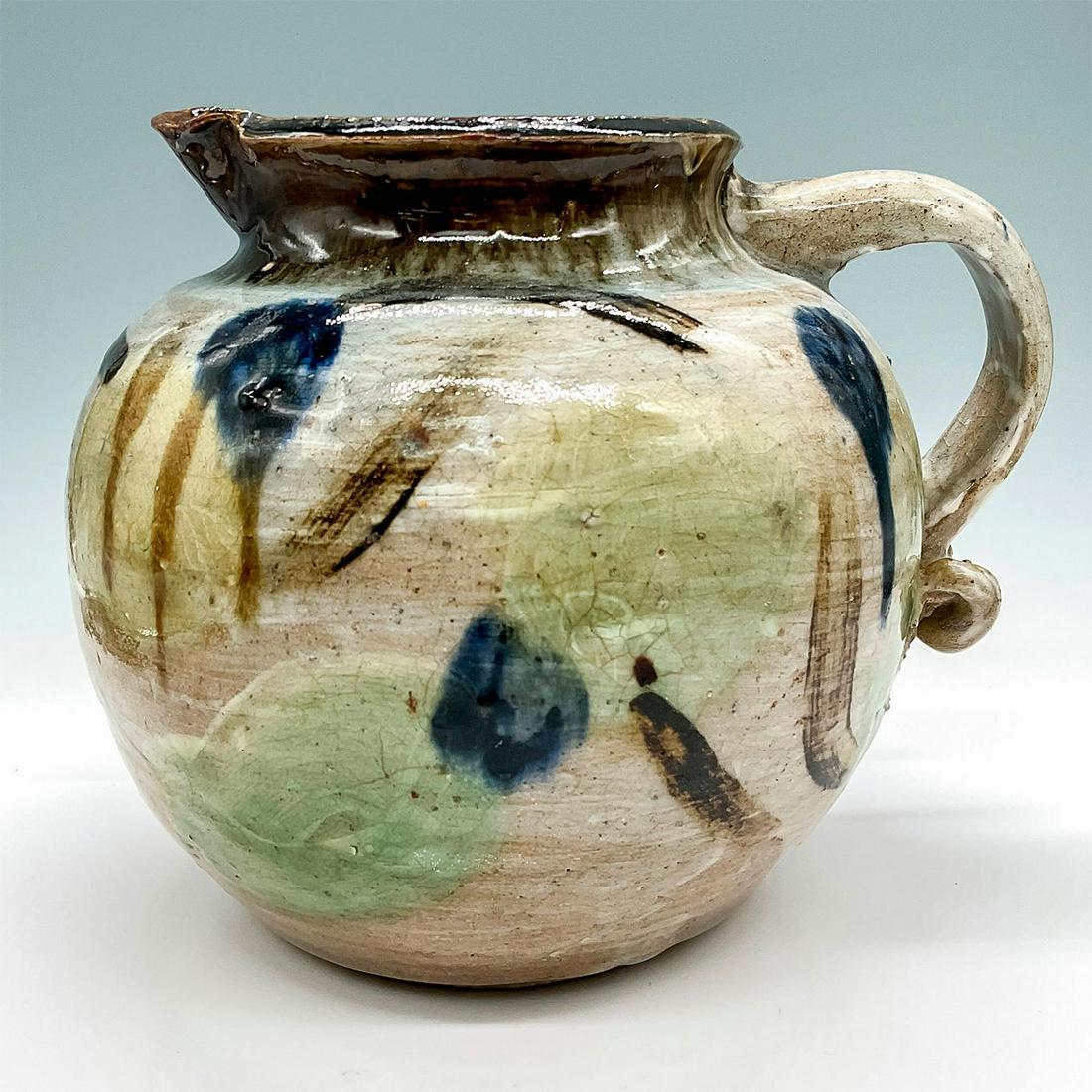 Vintage Arnold Signed Stoneware Pitcher: Glaze finish, handcrafted round pitcher decorated in soft earthy colors. Signed Arnold to bottom. Artist: Arnold Dimensions: 9.75"W x 8.75"H