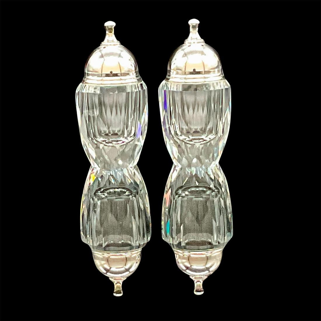 Pair of Swarovski Crystal Salt and Pepper Shakers: Small faceted shakers with silver-tone metal tops. Square Silver Crystal SC acid marks. Includes original box: 4in x 5in. Issued: Circa 1976-1988 Dimensions: 2.5"H x 1.5"Dia. Country of Origin: Austri
