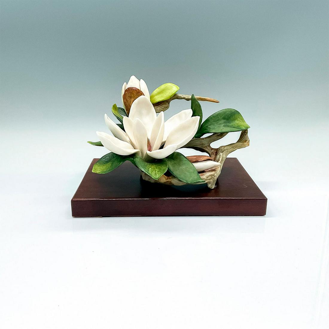 2pc Cybis Porcelain Sculpture with Base, Magnolia: A beautiful naturalistic floral figure of a white blossom and green leaves. Cybis mark on the side. This item has a base included: 8.5"L x 6"W x 1"H. Artist: Lynn Klockner Brown Issued: c. 1963-1975 D