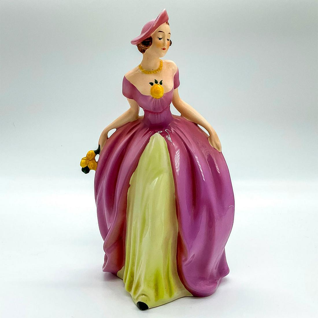 Goebel Hummel Figurine, Southern Belle FF70: Hand painted stunning figure of woman dressed in a pink and yellow off the shoulder dress with matching hat; holding a bouquet of yellow roses. Goebel backstamp on base and model number impressed on u