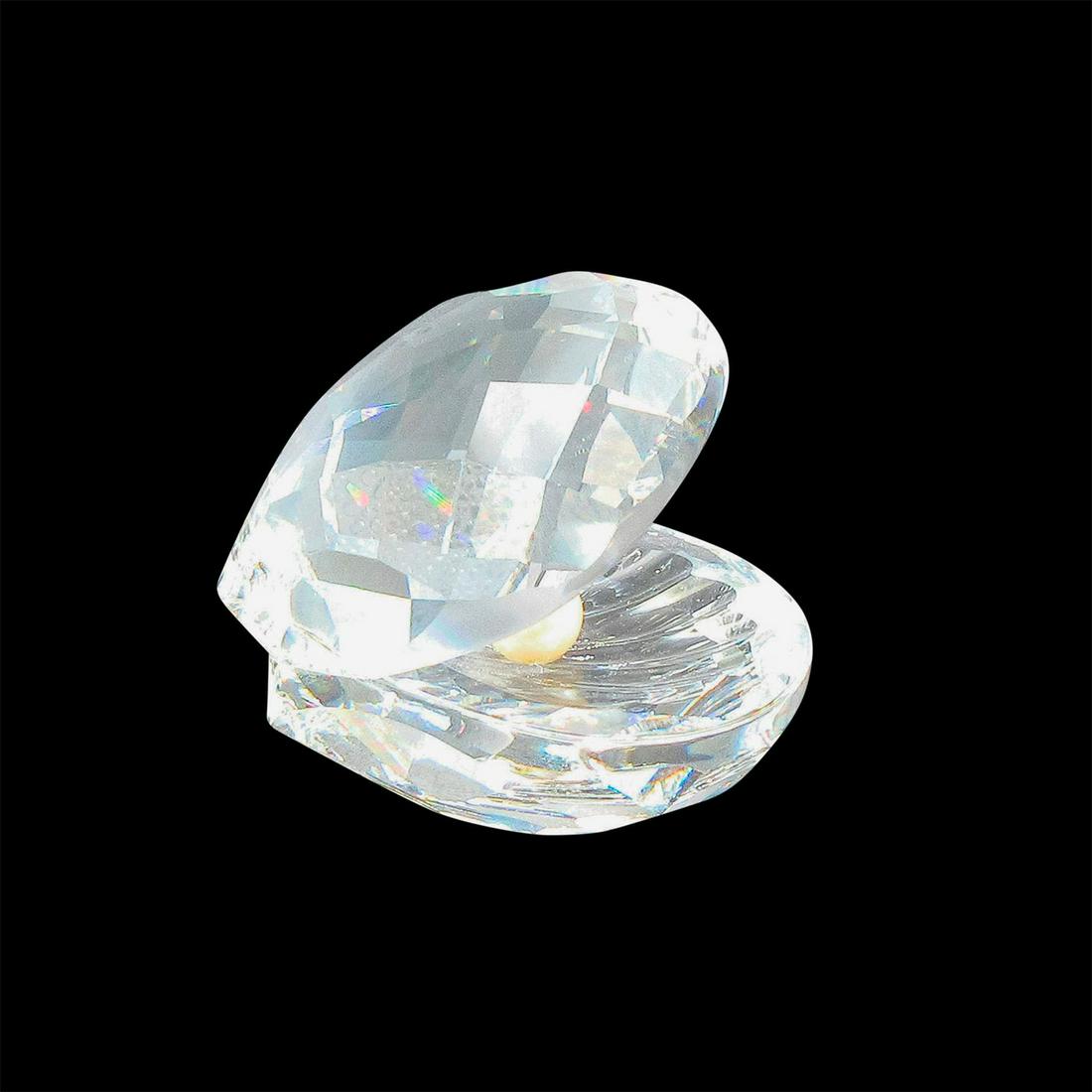 Swarovski Silver Crystal Figurine, Clam with Pearl: Open clam with beautiful facets to catch the light. Swarovski backstamp. 7624 NR 055 000. This item has its original box: 4"L x 4"W x 5"H. Artist: Michael Stamey Issued: 1988-2017 Dimensions: 2.5"L x