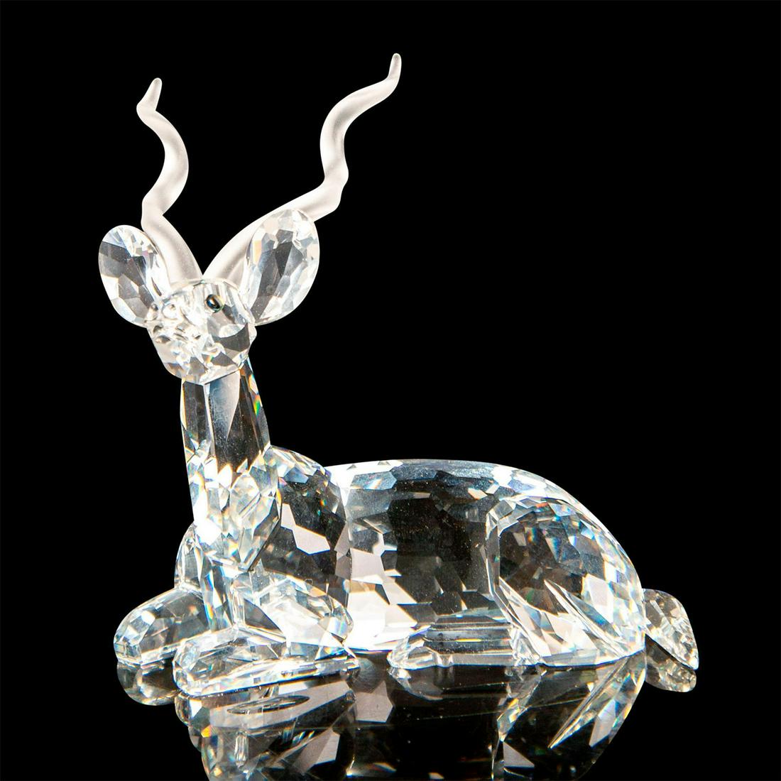 Swarovski Crystal Figurine, Kudu 175703: Brilliant cut crystal figure of a kudu, a type of antelope, lying down resting, with satin horns. Swarovski etched mark. Includes original box, 7.5"L x 8"W x 6.5"H. Issued: 20th c. Dimensions: 4"L x 3