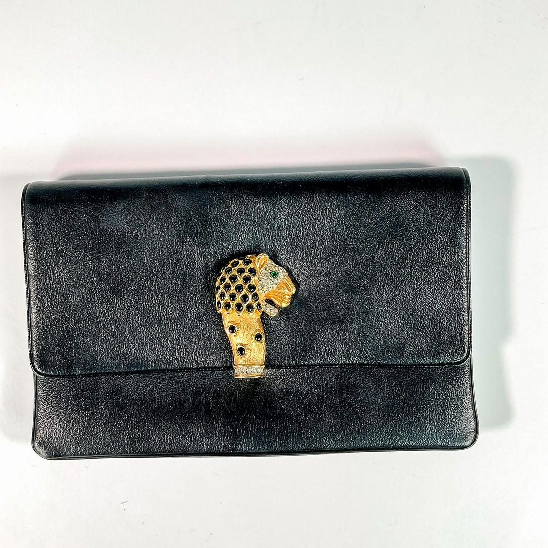 Rosenfeld Leather Clutch with Lion Head: A black purse adorned with a Kenneth Jay Lane style embellished lion head. Faux emerald eye with rhinestone face, and black enamel mane. Rosenfeld marked on the inside. Dimensions: 10.25"L x 1.25"W x