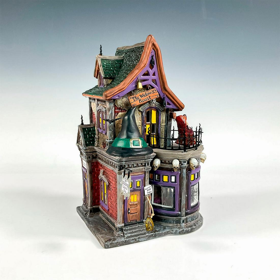 Department 56 Lighted Figurine, Be Witching Costume Shop: The Original Snow Village series and 30th Anniversary Collectors' Surprise. A ceramic figure in a semi-glossy finish. Depicts a costume shop with built in light fixture. Includes removable pieces. Dep