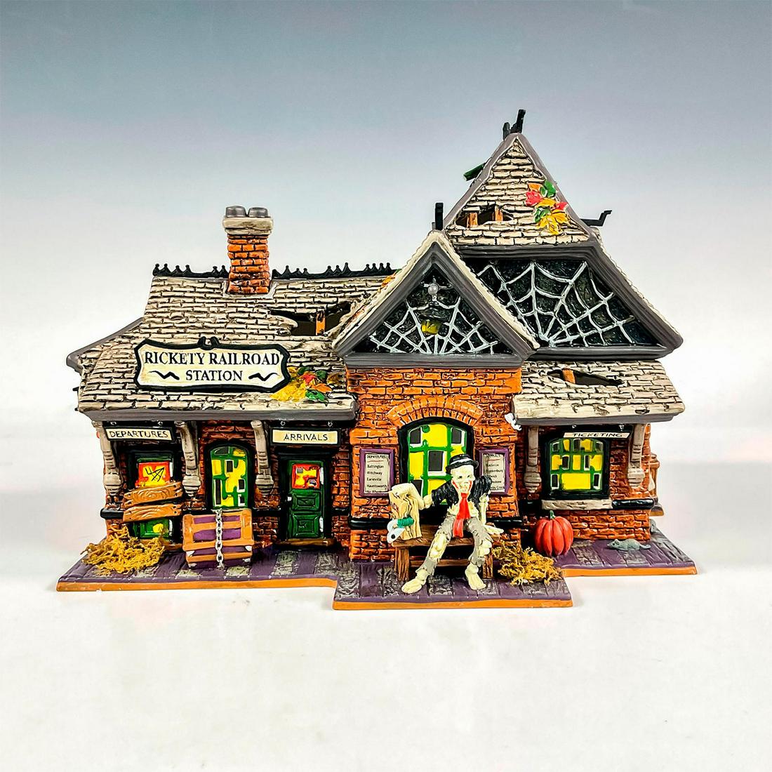 Department 56 Figure, Rickety Railroad Station: This collectible porcelain building designed for the Snow Village Halloween collection, depicts a vintage and weathered railroad station, creating a spooky addition to your Halloween village display. 