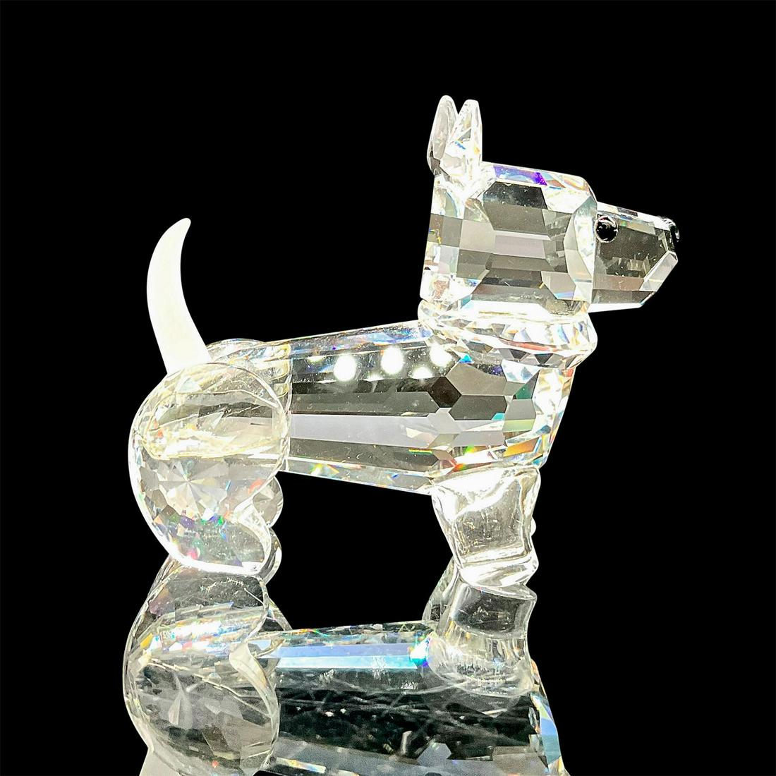 Swarovski Silver Crystal Figurine, Puppy: A clear faceted body of a puppy with a frosted tail. Swarovski mark. This item has its original box: 3.25"W x 3.75"H. Artist: Adi Stocker Issued: 1990-1996 Dimensions: 2"L x 0.75"W x 1.5"H Manufacture