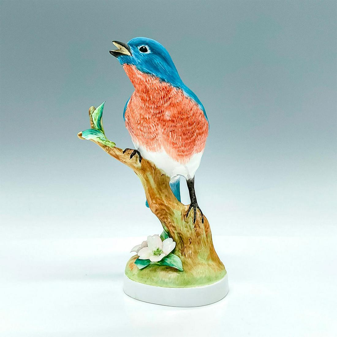 Crown Staffordshire Figurine, Blue Bird: Portrays a blue and peach bird perched on a branch with flowers growing on the base. Underside is Crown Staffordshire backstamped and signed. Artist: Doris Lindner Issued: 20th century Dimensions: 4.2