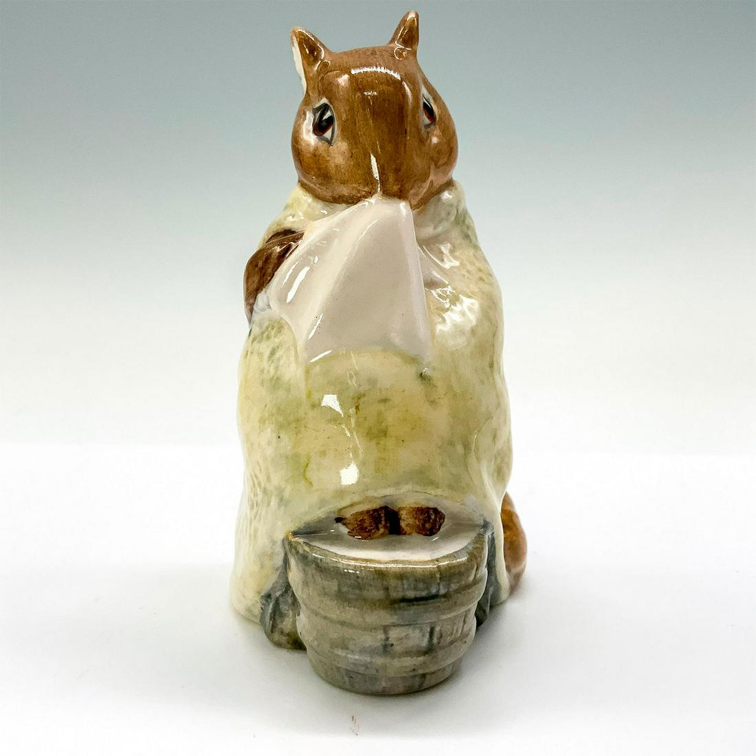 Beswick Beatrix Potter Figurine, Chippy Hackee: A figurine of a squirrel taking a foot bath while wrapped in a pale-yellow blanket. Beswick backstamp. Dimensions: 1.75"L x 2.25"W x 3.5"H Manufacturer: Beswick Country of Origin: England