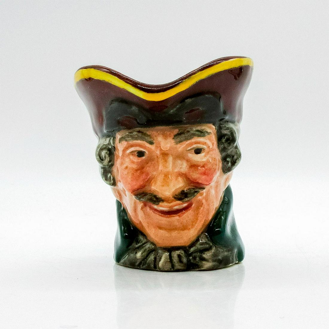Dick Turpin D6128 (Pistol Handle) - Mini - Royal Doulton Character Jug: Style One, pistol handle. Brown hat; mask up; green coat; white cravat. Dick Turpin (1705 - 1739) joined forces with fellow highwayman Tom King, whom he accidentally shot. Before he died, King betraye