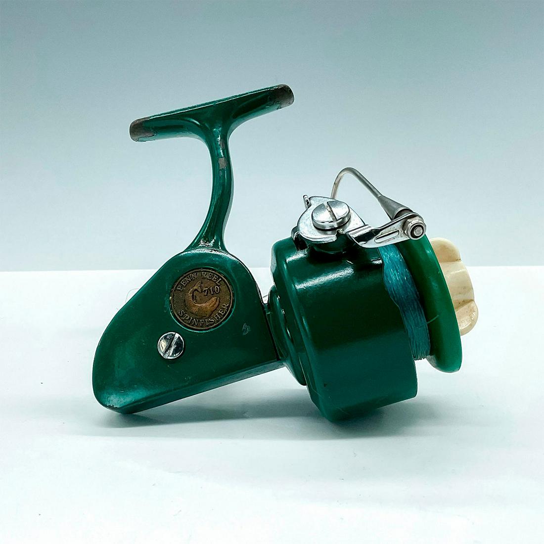 Vintage Penn 710 Spinfisher Spinning Reel: Classic Greenie reel with embossed shield which reads, "Penn Reel 710 Spinfisher." Issued: 20th Century Dimensions: 5.5"L x 4.5"W x 5.5"H Manufacturer: Penn Country of Origin: USA