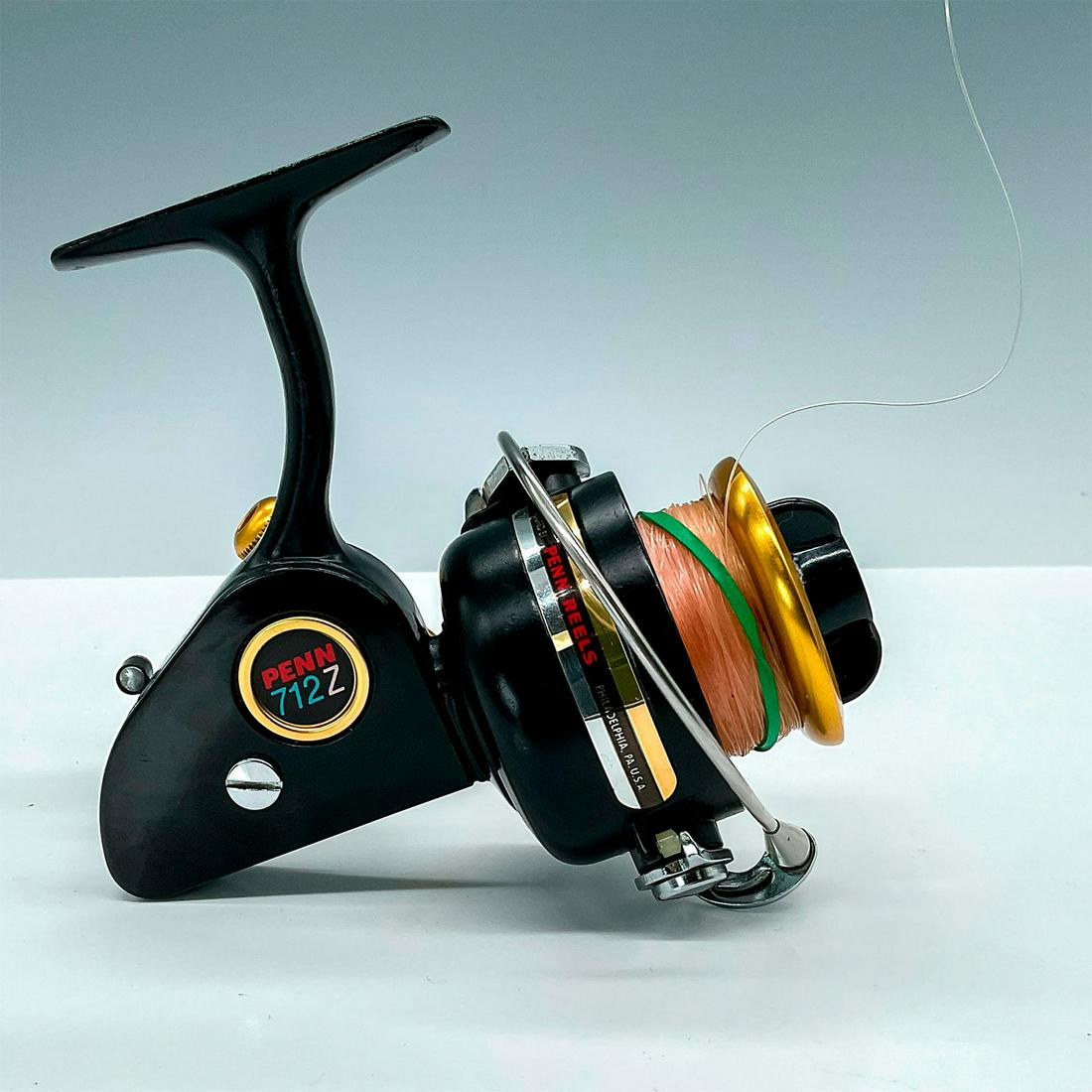 Vintage Penn 712Z Spinning Reel: Second generation of the 700 Series. Nice looking black base with gold handle and spool, line cap for 12 lbs. is 150 yds. Issued: c. 1970 Dimensions: 5.5"L x 4"W x 5"H Manufacturer: Penn Country of Or