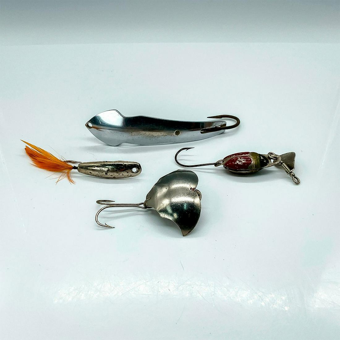 4pc Vintage Metal Lures Acetta, Batwing, Wemac, Beetlebug: The longest lure, Tony Accetta Pet Spoon #17 stamped on underside with fixed hook and measurements of 4.25"L. Batwing marked made in USA with one double hook. WEMAC feathered jig. Lastly, the Lur-All 