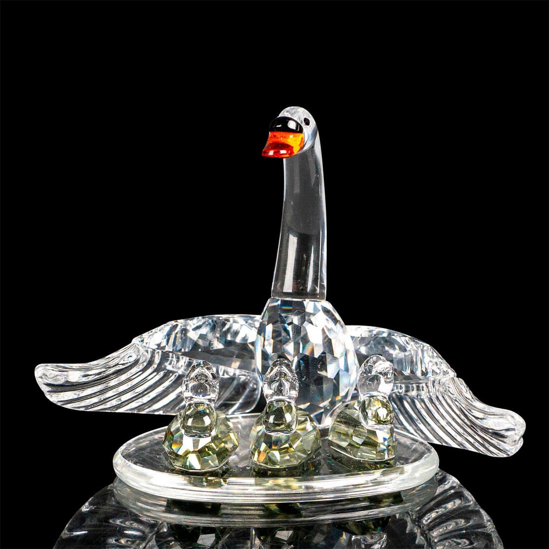 Swarovski Crystal Figure, Swan Mother with Cygnets: Swan family was part of the "Beauties of the Lake" collection. The family sit on a round, flat base to which they are all attached. The 3 baby swans (cygnets) are made from a shade of crystal called b