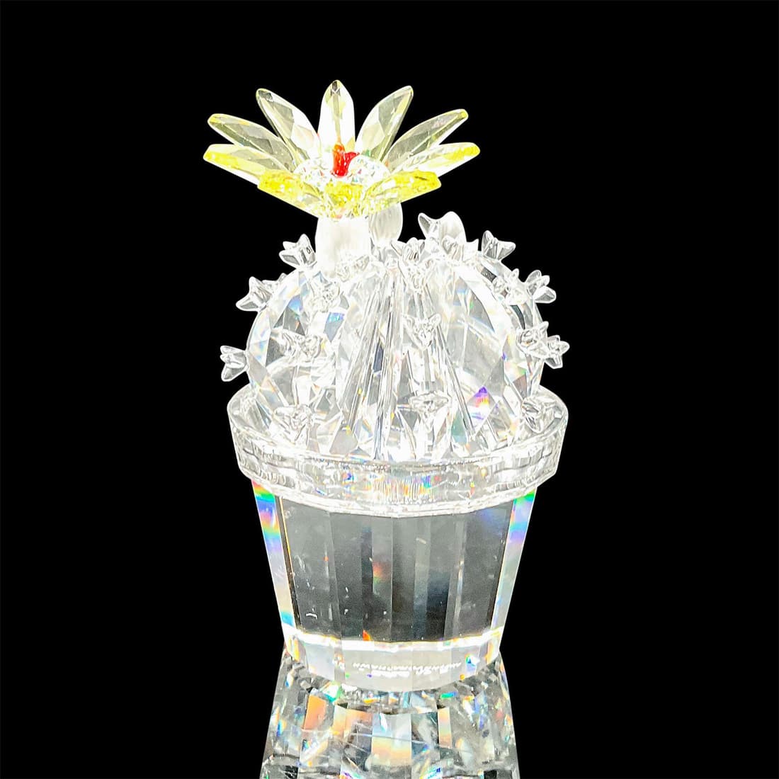 Swarovski Crystal Figurine, Flowering Cactus 291549: Part of the Exquisite Accents collection. Lead crystal cactus flowering with yellow crystal jonquil. Swarovski etched backstamp. Artist: Michael Stamey Issued: 2002-2004 Dimensions: 1.5"W x 2.75"H Man