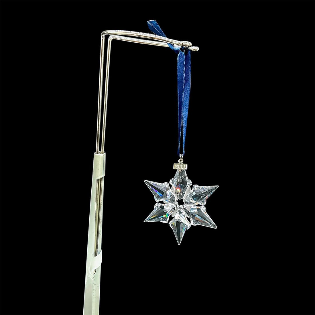 Swarovski Crystal Christmas Ornament 2000: Stunning star shaped clear cut crystal Christmas ornament. Swarovski etched mark. Issued: 2000 Dimensions: 3"L x 0.5"W x 3.25"H Manufacturer: Swarovski Country of Origin: Austria