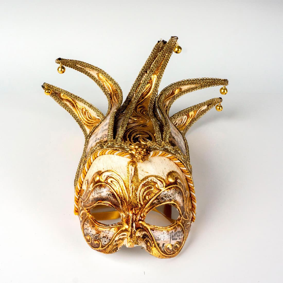Authentic Venetian Colombina Jolly Musica Mask: Beautiful face mask decorated with musical notes on traditional paper. It's finished with gilded fabric and gold satin ribbons. Made in Venice Italy stamp impressed. Dimensions: 7.5"L x 6.25"W x 4.5"D