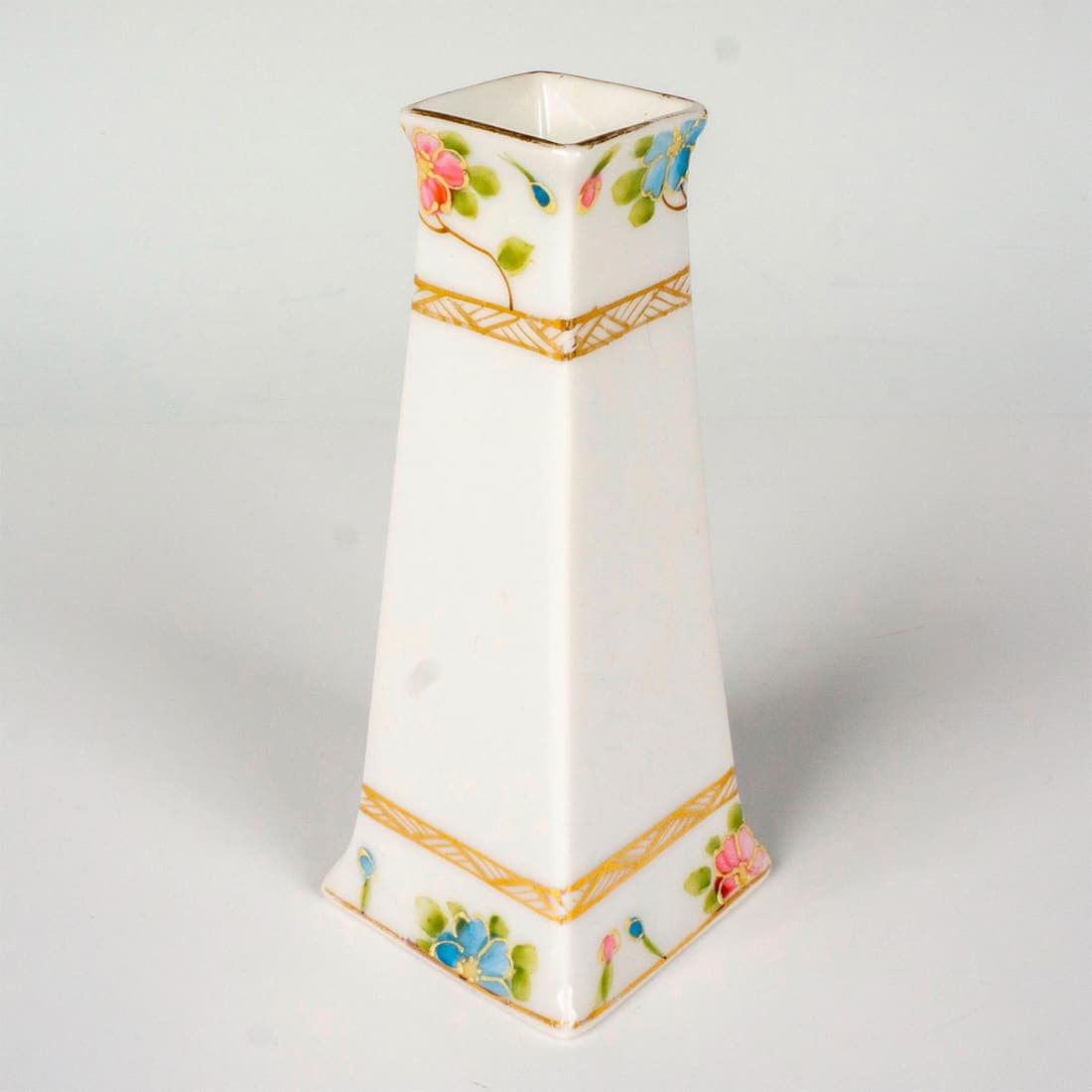Antique Nippon Porcelain Hatpin Holder: A hand painted vessel decorated with pink and blue flowers, gilded trim accents. Nippon backstamp. Dimensions: 2"L x 2"W x 4.75"H Manufacturer: Nippon Country of Origin: Japan