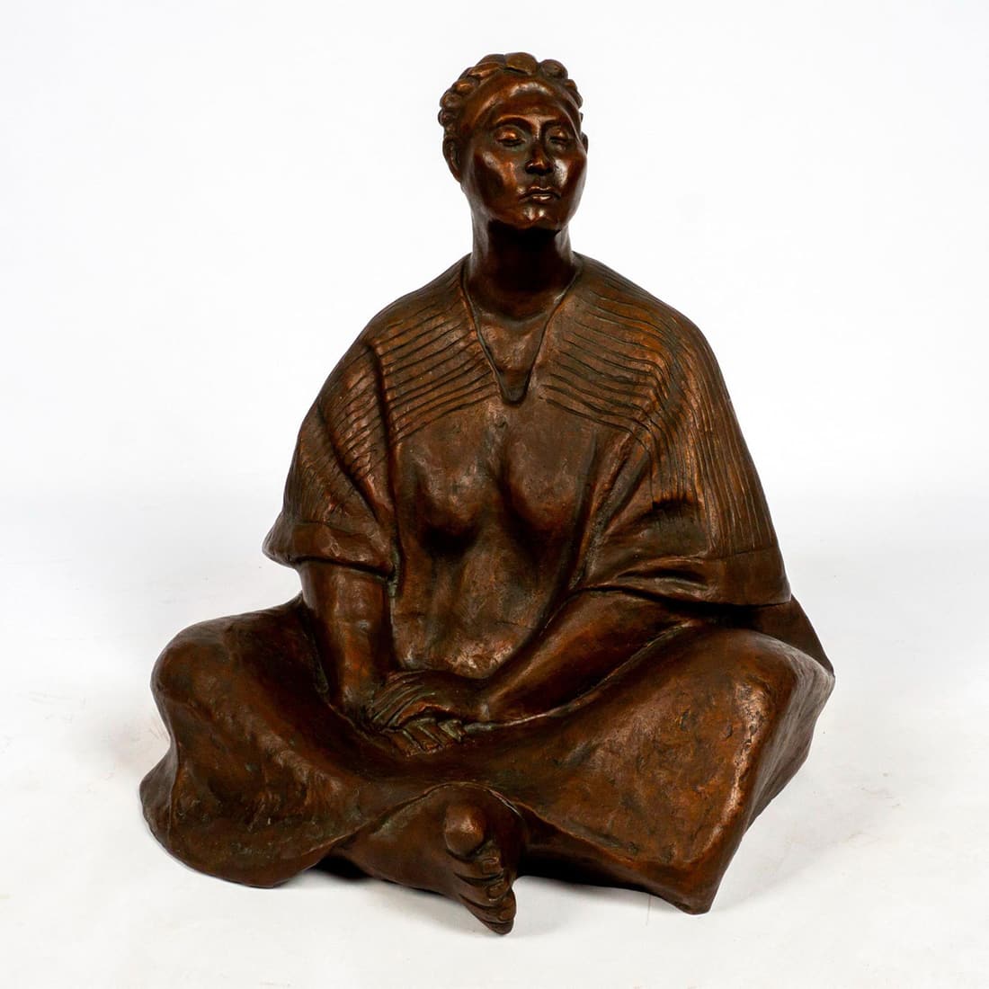 Bronze Sculpture in the Style of Francisco Zuniga: Imposing bronze cast sculpture with patinated areas that depicts a seated woman with braided hair and a wrapped shawl in a style borrowed from Francisco Zuniga's series of women seated on the ground.