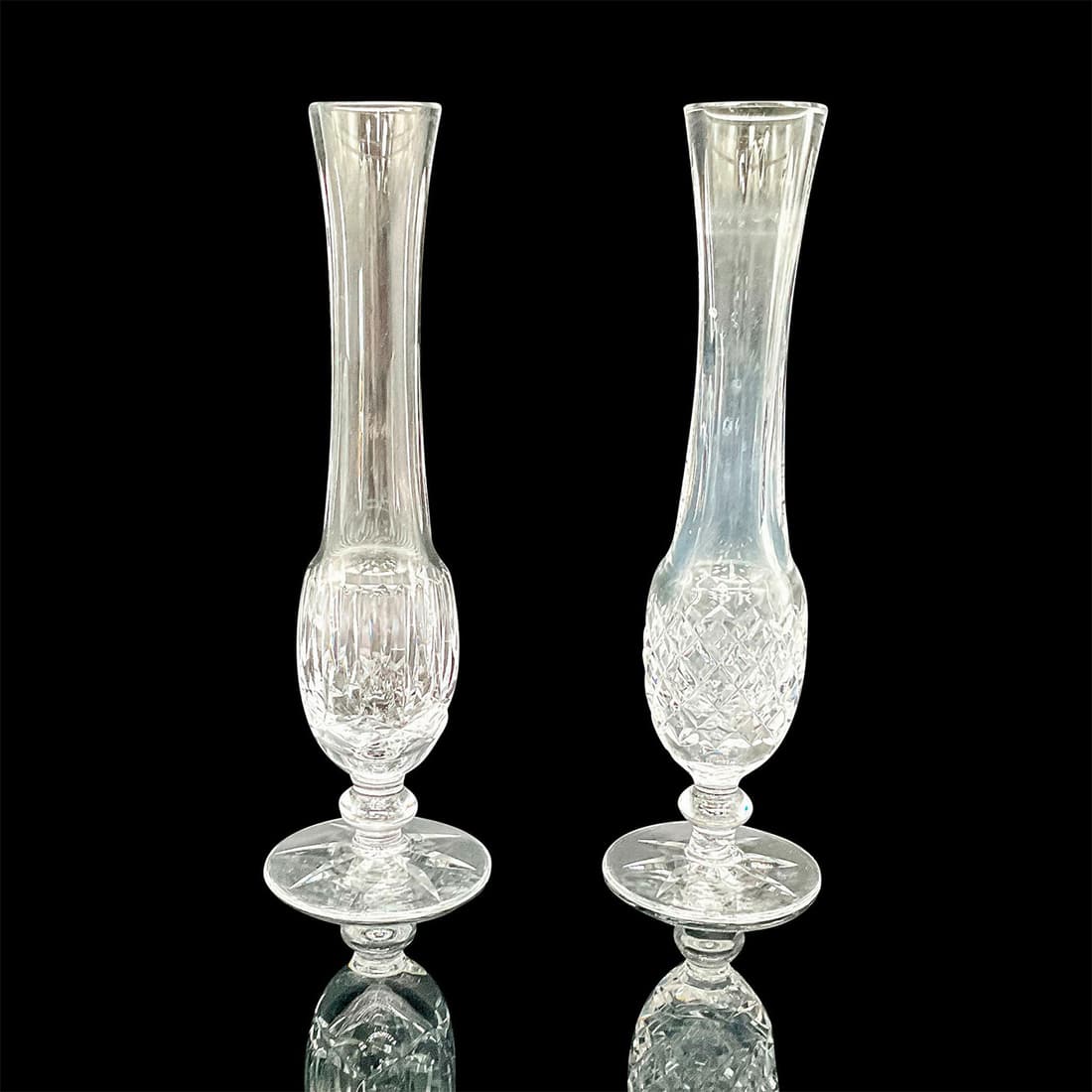 2pc Waterford Crystal Bud Vases: A set of 2 beautiful clear single flower footed vases. One with vertical and crisscross cuts, and the other in a diamond cut design. Waterford acid marks on the bases. Dimensions: 2.75"W x 9.25"H Manu