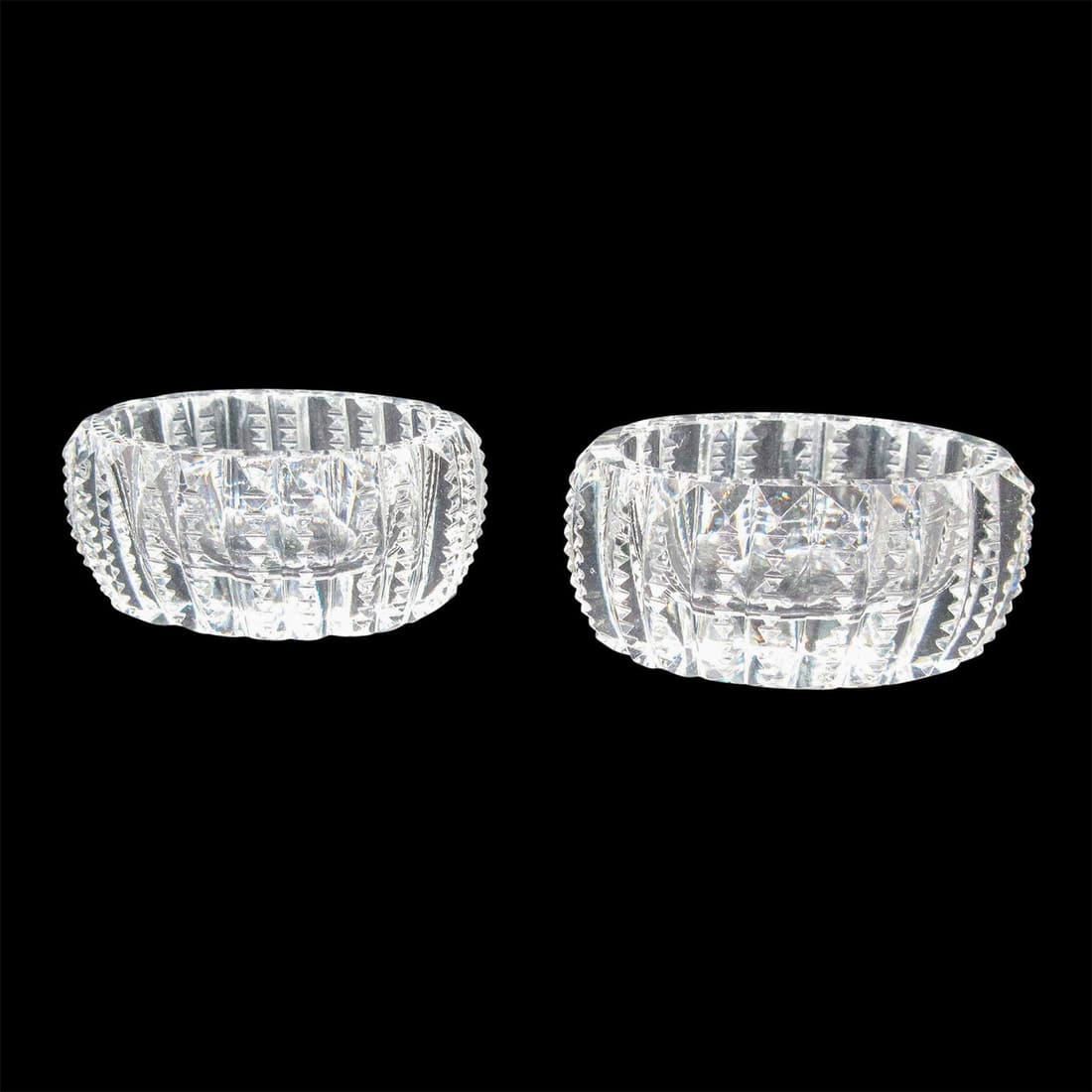 Pair of Vintage Oval Glass Salt Cellars: Translucent salt cellars decorated with vertical and diamond-shape cut designs. This item has no reserve. Dimensions: 2.25"L x 1.75"W x 1"H