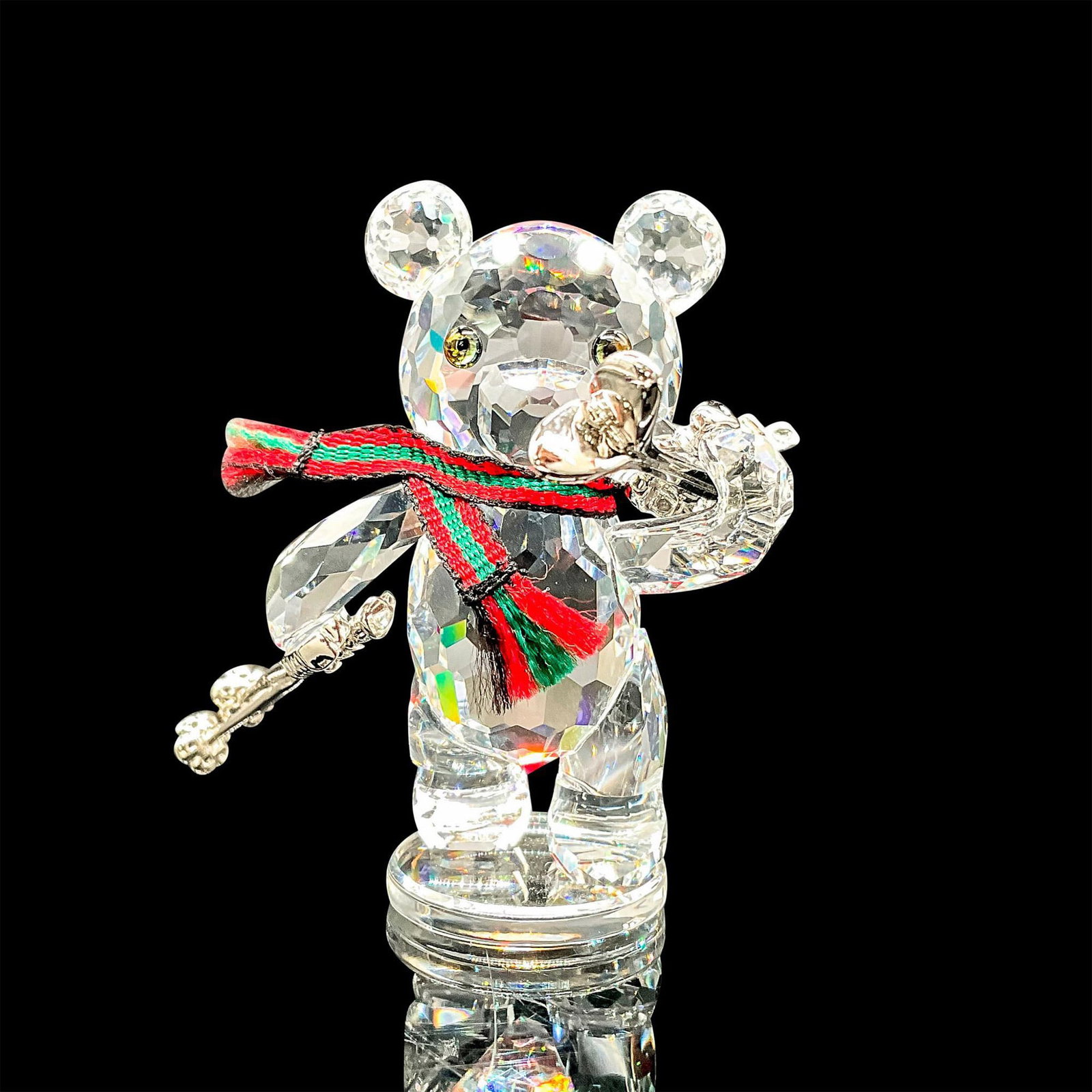Kris Bear with Skis - Swarovski Crystal Figurine: This Kris Bear with skis was part of the When we were Young theme. Kris Bear wears a ribbon of green and red fabric around his neck, and carries rhodium skis. Swarovski etched backstamp. This item has