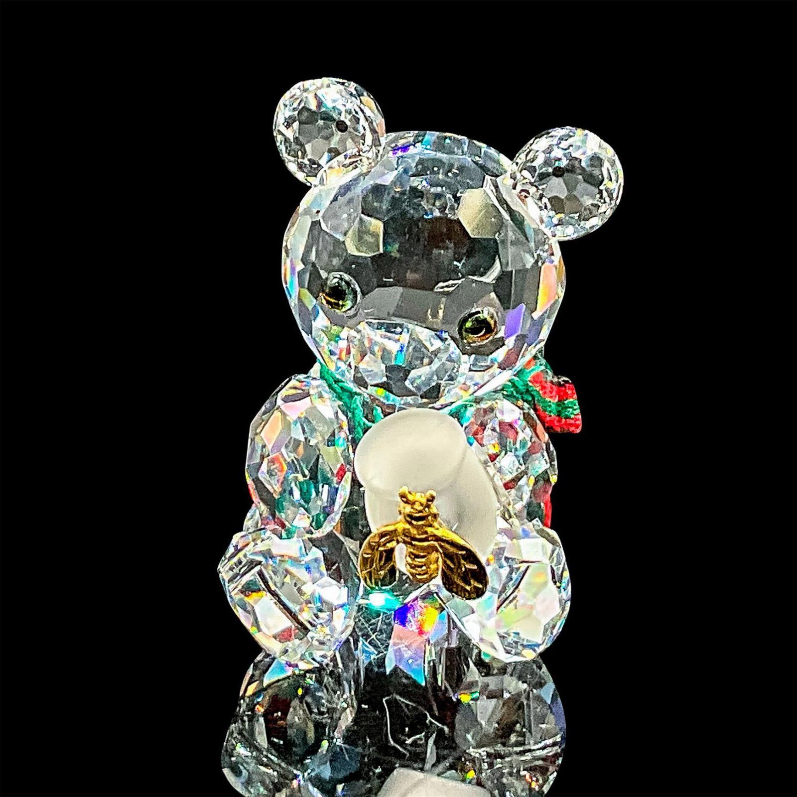 Holiday Kris Bear With Honey Pot - Swarovski Crystal Figurine: Brilliant clear crystal Kris Bear holding a satin jar with a gold bee. Swarovski etched backstamp. Includes original box 2.5"H x 3.25"dia. Certificate of Authenticity included. Dimensions: 1.25"L x 1"