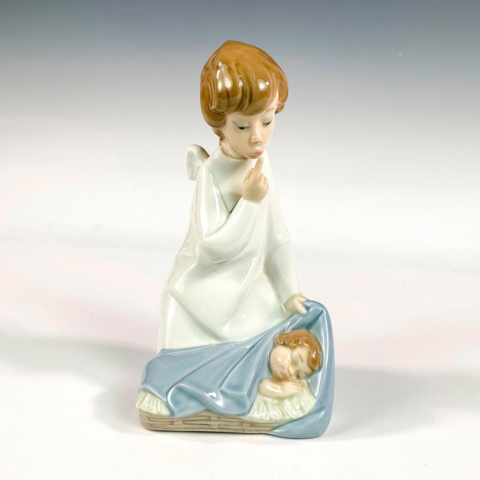 Angel With Child 1004635 - Lladro Porcelain Figurine: Glossy finish; Lladro backstamp. Artist: Juan Huerta Issued: 1969 - 2002 Dimensions: 7"H x 3.5"W Manufacturer: Lladro Country of Origin: Spain