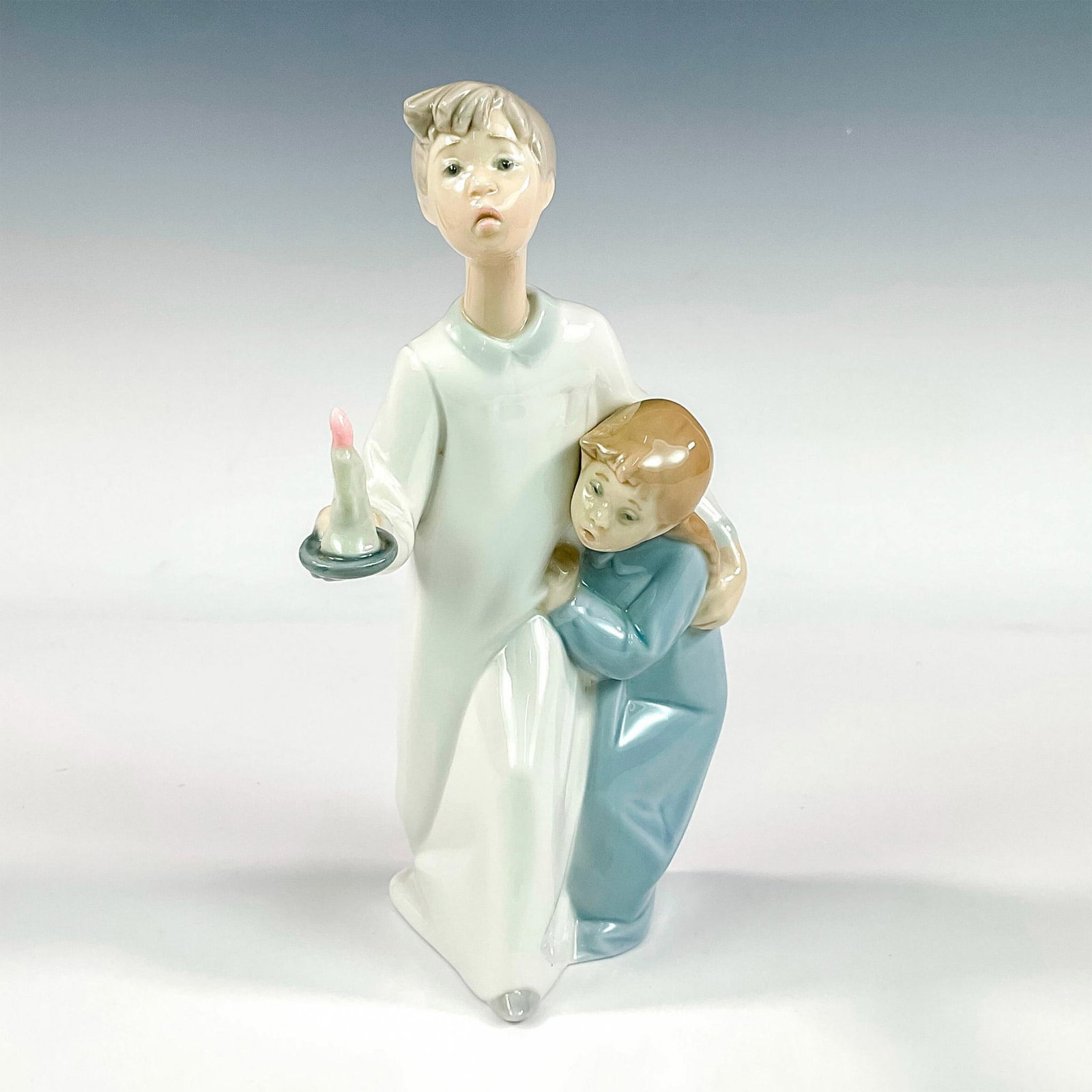 Boy And Girl 1004874 - Lladro Porcelain Figurine: Glossy finish; Lladro backstamp. Artist: Fulgencio Garcia Issued: 1974 - 1997 Dimensions: 8.25"H x 5"W Manufacturer: Lladro Country of Origin: Spain