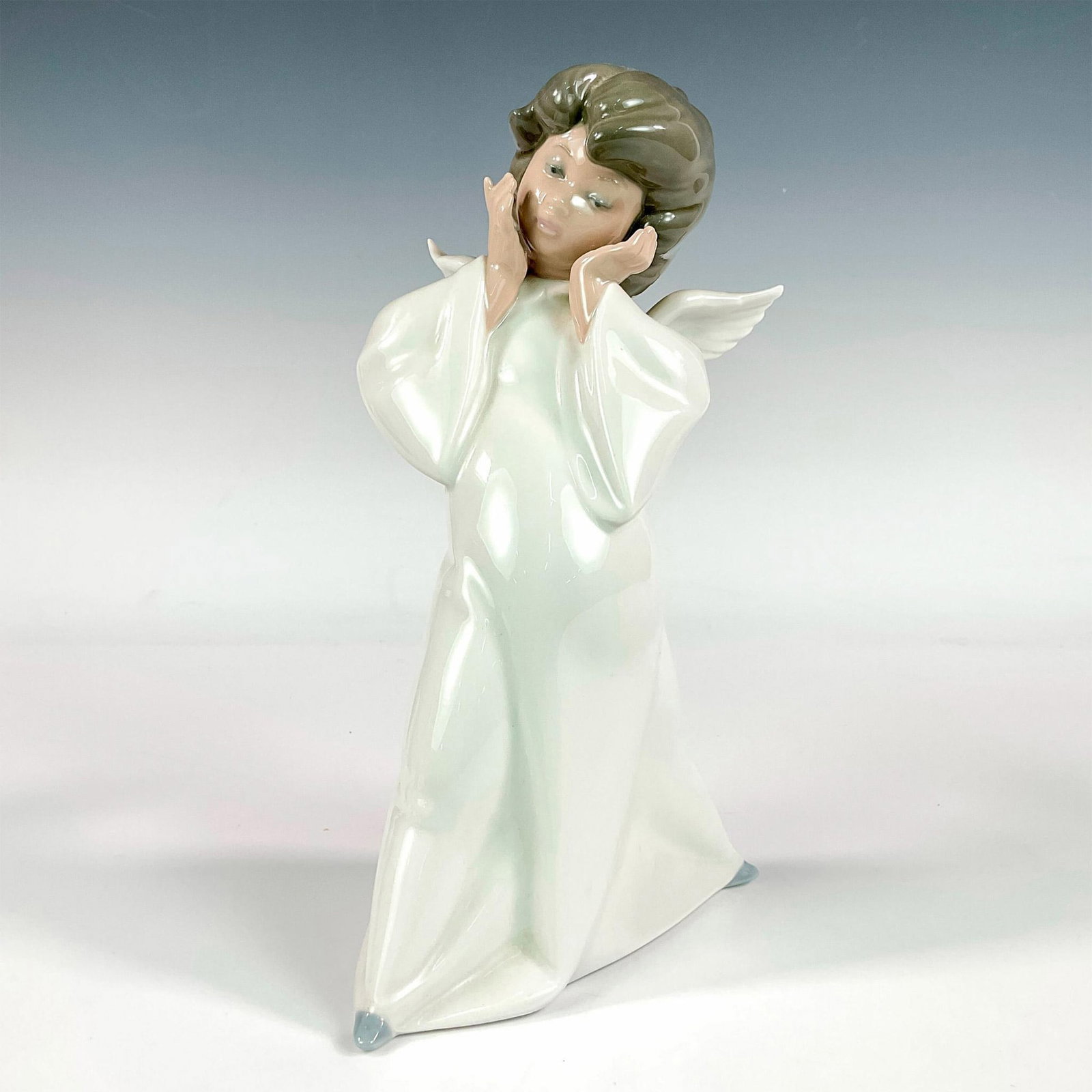 Cherub, Puzzled 1004959 - Lladro Porcelain Figurine: Glossy finish; Lladro backstamp. Artist: Salvador Debon Issued: 1977 Dimensions: 8.75"H x 5"W Manufacturer: Lladro Country of Origin: Spain