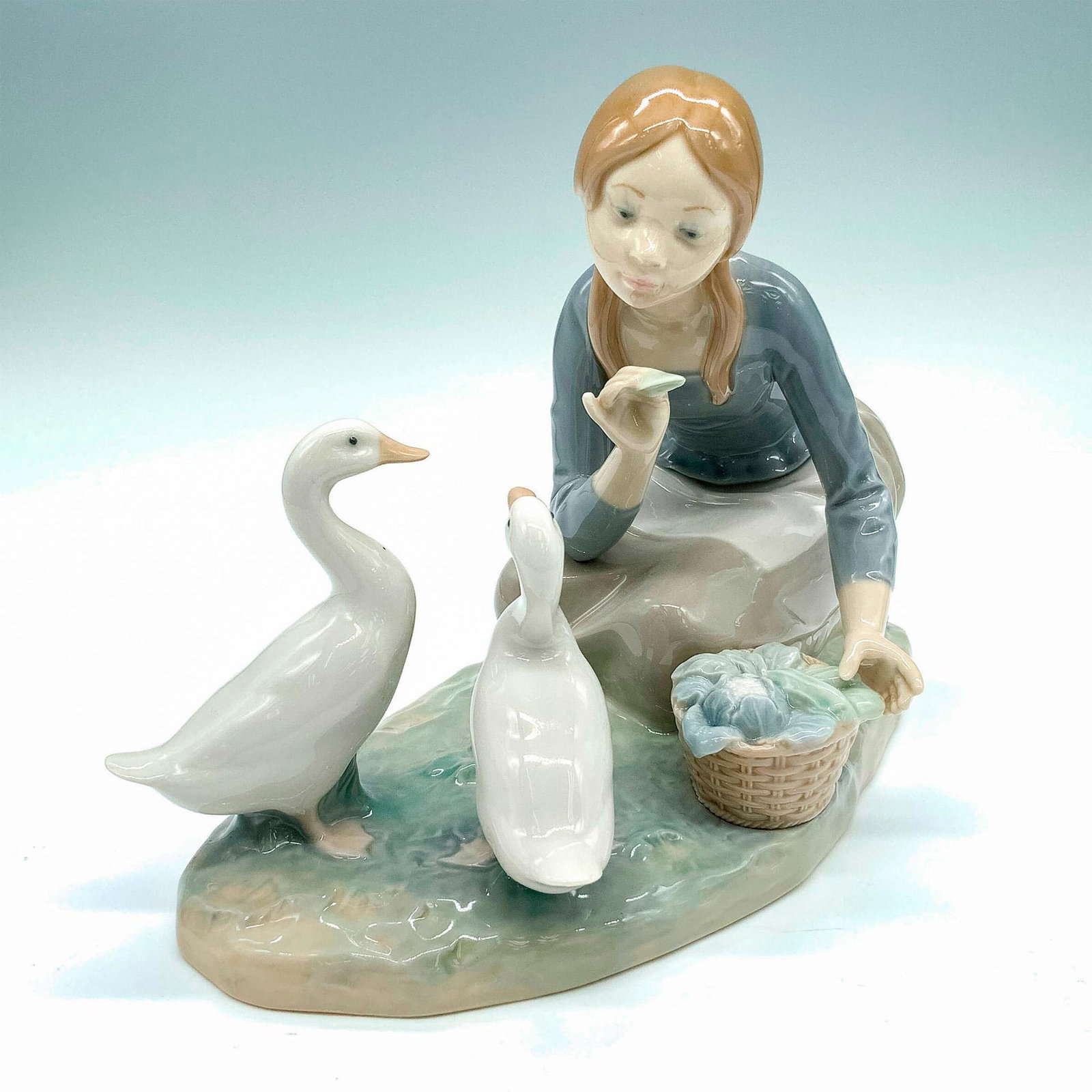 Feeding the Ducks 1004849 - Lladro Porcelain Figurine: Glossy finish; Lladro backstamp. Artist: Alfredo Ruiz Issued: 1973-1995 Dimensions: 9.25"L x 4.75"W x 6.75"H Manufacturer: Lladro Country of Origin: Spain