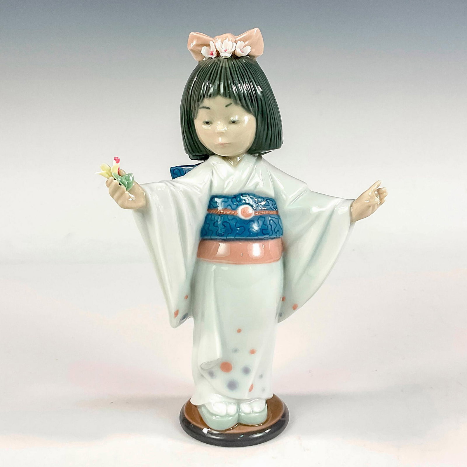 Flower Gazer 1006152 - Lladro Porcelain Figurine: Glossy finish; Lladro backstamp. Artist: Salvador Debon Issued: 1994 - 1999 Dimensions: 7.5"H Manufacturer: Lladro Country of Origin: Spain