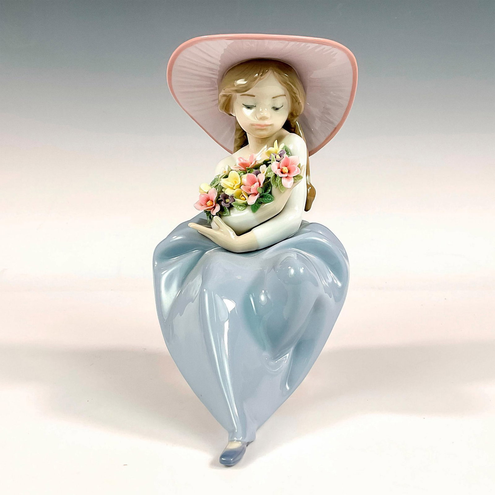 Fragrant Bouquet 1005862 - Lladro Porcelain Figurine: Glossy finish; Lladro backstamp. Includes original box. Box measures: 9.25"L x 10.5"W x 8"H. Artist: Antonio Ramos Issued: 1992 Dimensions: 7.75"H x 6.25"W Manufacturer: Lladro Country of Origin: