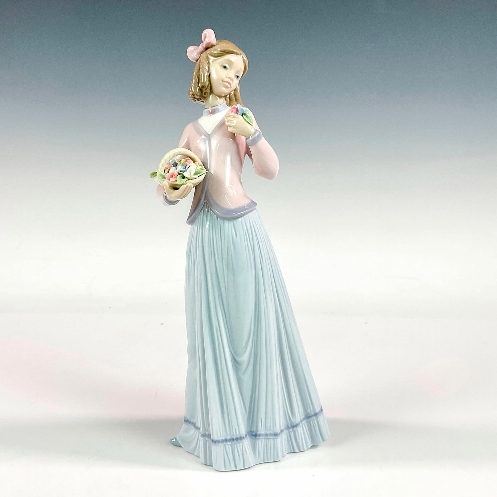 Innocence In Bloom 1007644 - Lladro Porcelain Figurine: Glossy finish; Lladro backstamp. Includes original box. Box measures: 6.75"L x 12"W x 5.5"H. Artist: Jose Puche Issued: 1996 - 1996 Dimensions: 9.75"H x 4.25"W Manufacturer: Lladro Country of Origin:<