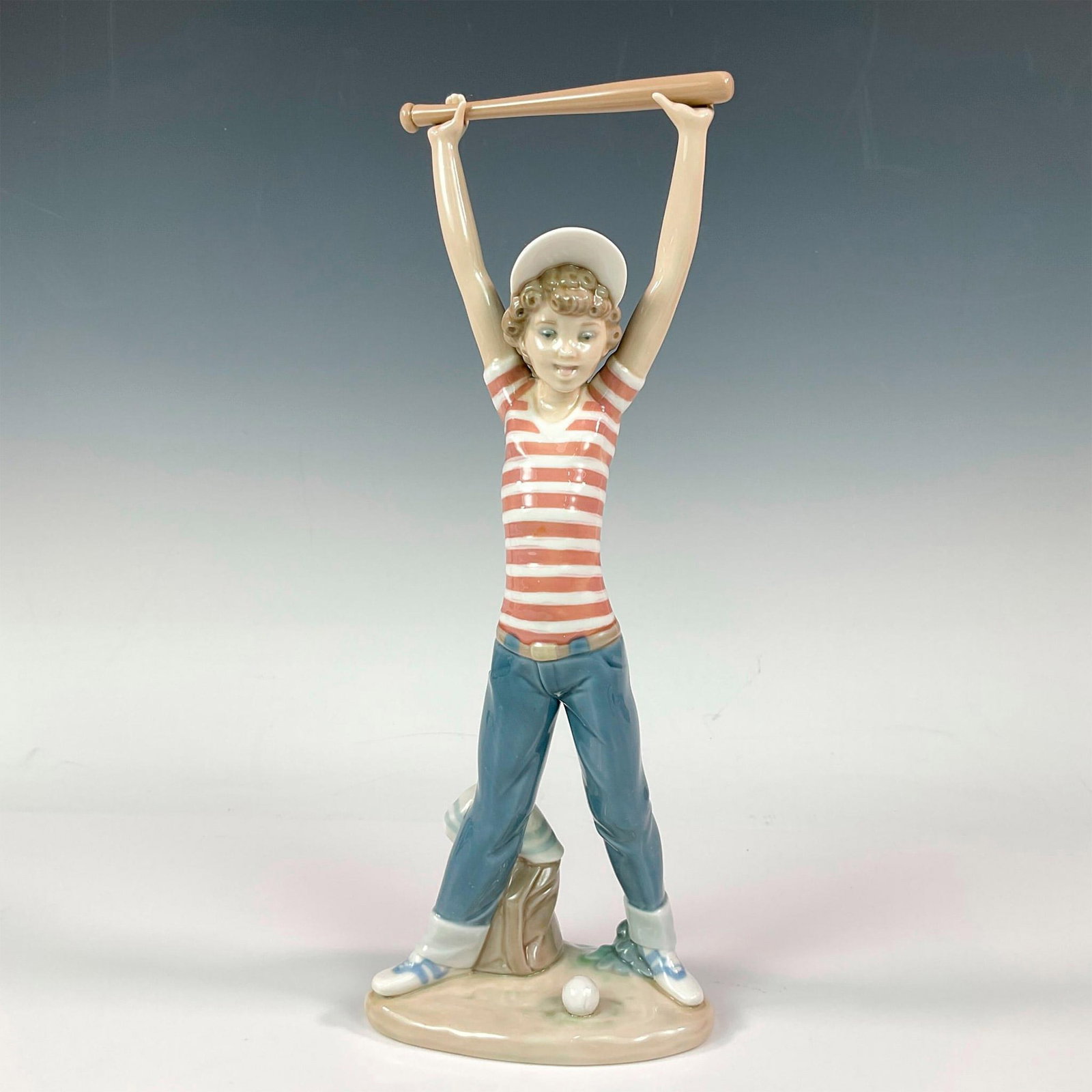Little Leaguer Exercise 1005289 - Lladro Porcelain Figurine: Glossy finish; Lladro backstamp. Artist: Salvador Debon Issued: 1985 - 1989 Dimensions: 12.25"H Manufacturer: Lladro Country of Origin: Spain