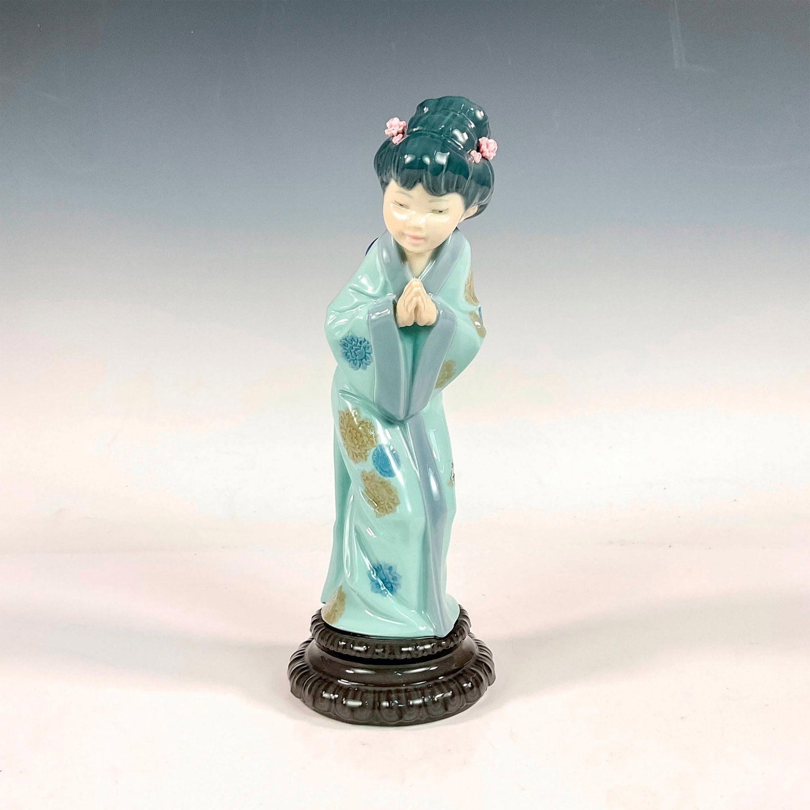 Sayonara 1004989 - Lladro Porcelain Figurine: Glossy finish; Lladro backstamp. Artist: Salvador Debon Issued: 1978-1996 Dimensions: 3.75"L x 4"W x 10.25"H Manufacturer: Lladro Country of Origin: Spain