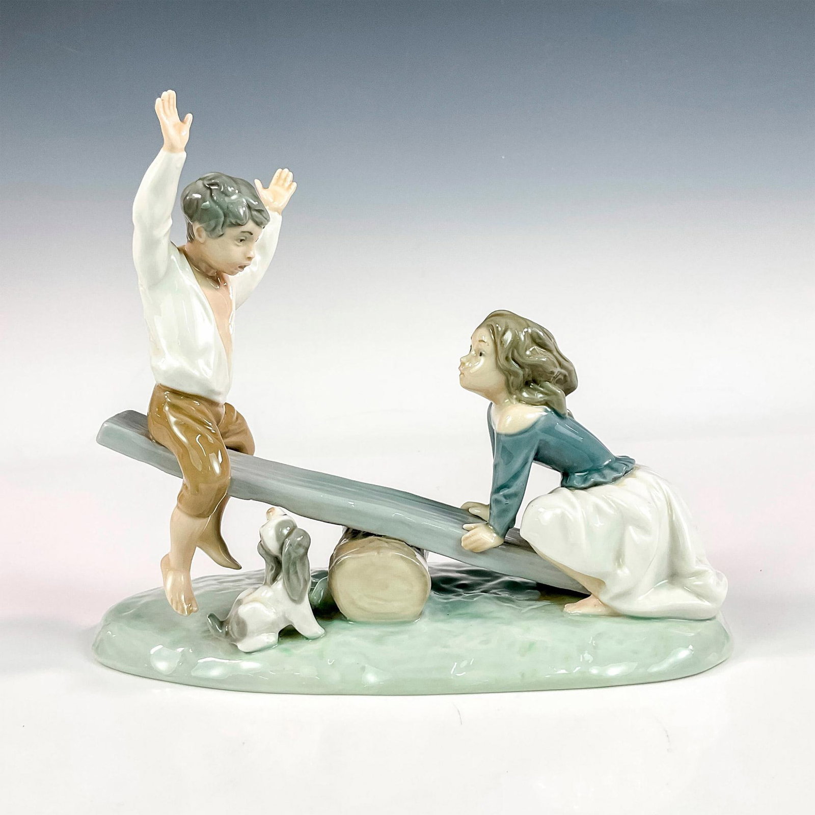 See-saw 1004867 - Lladro Porcelain Figurine: Glossy finish; Lladro backstamp. Artist: Fulgencio Garcia Issued: 1974 - 1996 Dimensions: 7.75"H x 9"W Manufacturer: Lladro Country of Origin: Spain
