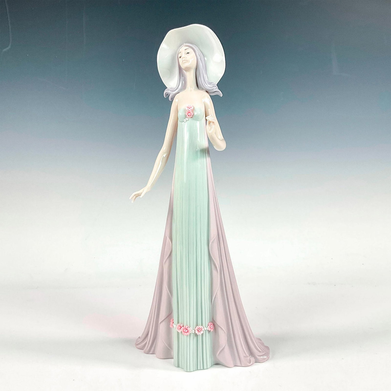 The Debutante 1001431 - Lladro Porcelain Figurine: Glossy finish; Lladro backstamp. Artist: Jose Puche Issued: 1982 - 1998 Dimensions: 13.75"H x 6.25"W Manufacturer: Lladro Country of Origin: Spain