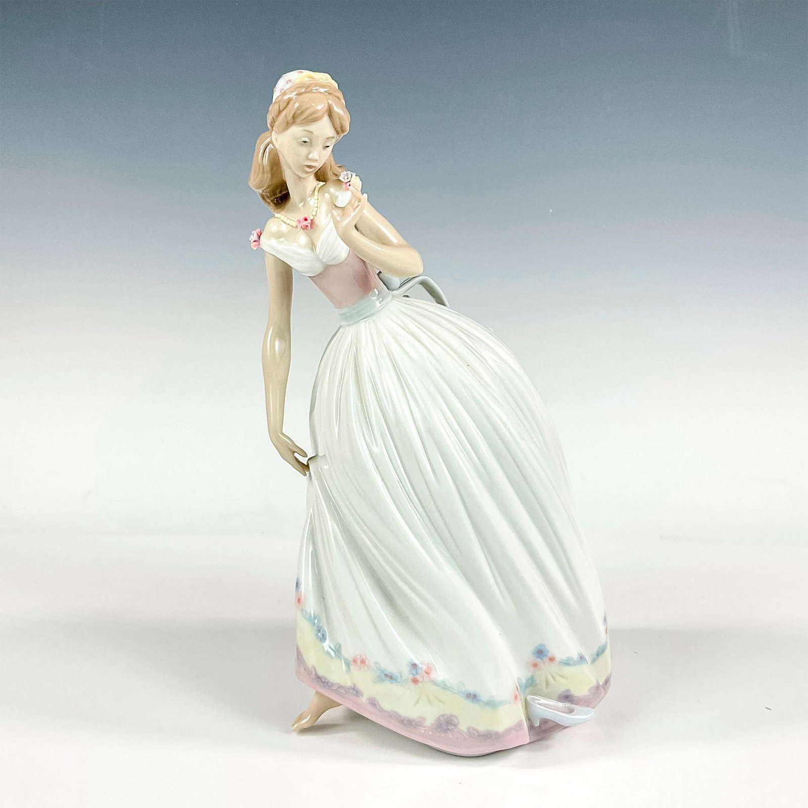 The Glass Slipper 1005957 - Lladro Porcelain Figurine: Glossy finish; Lladro backstamp. Includes original box. Box measures: 9.5"L x 13.5"W x 8.25"H. Artist: Jose Puche Issued: 1993 - 2001 Dimensions: 10.25"H x 6.75"W Manufacturer: Lladro Country of Origi