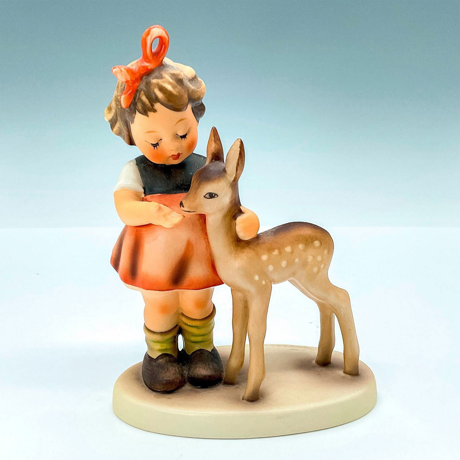 Goebel Porcelain Figurine, Girl with Fawn: This figurine was modeled in 1940 by Reinhold Unger. The white spots on the hide of the fawn are sometimes arranged in 3 rows, sometimes in 2 rows. The variant in terracotta finish is very limited and
