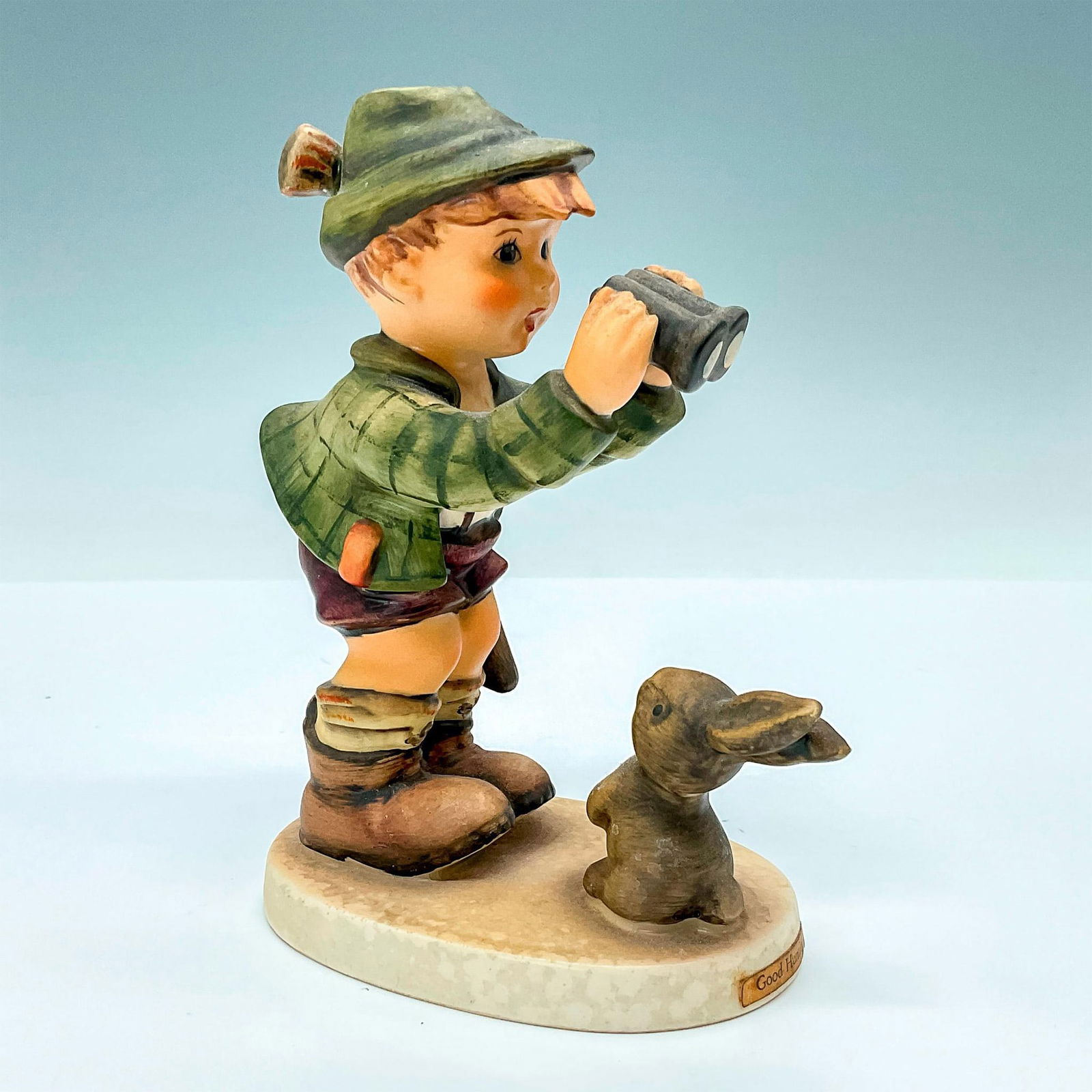 Goebel Porcelain Figurine, Good Hunting: Good Hunting #307 TMK4 figurine features a boy holding binoculars and a hunting rifle. In front of the boy stands a bunny. Goebel backstamp. Issued: 1964-1972 Dimensions: 3.75"L x 2.5"W x 5.5"H Manufa